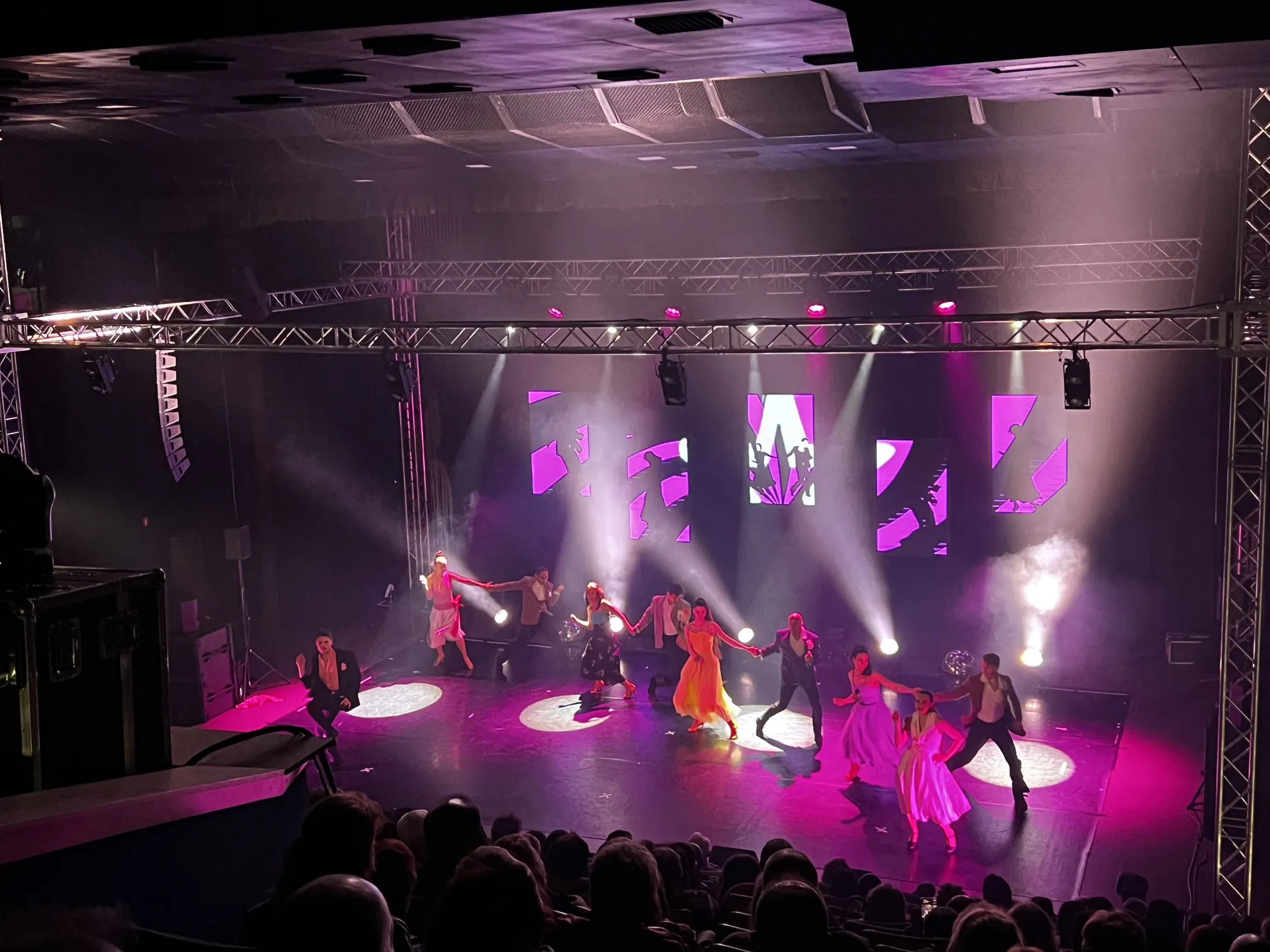 Розови лъчи през хейз, ферми с прожектори и окачен Line Array на сцена за мюзикъл